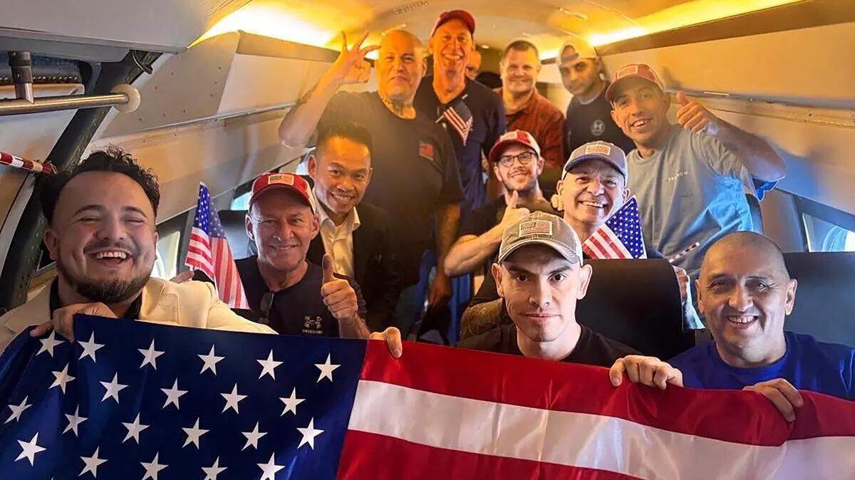 A State Department photo shows Americans and U.S. residents imprisoned in Venezuela. Dahud Hanid Ortiz is at center right, with a flag. The man flashing his three fingers is Renzo Huamanchumo, a Peruvian with U.S. resident status. The symbol was used by detainees to show they were hostages, according to one former prisoner.