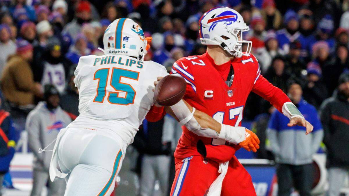 Miami Dolphins linebacker Jaelan Phillips (15) strip-sack Buffalo Bills quarterback Josh Allen (17) during fourth quarter of an NFL football game at Highmark Stadium on Saturday, December 17, 2022 in Orchard Park, New York.