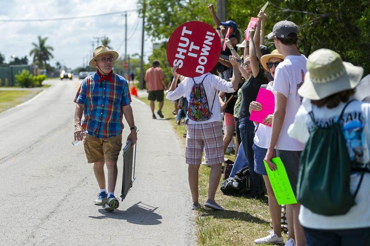 Larry Brown, 71, far-left, an activist, walks past a group of protestors outside of the Homestead Temporary Shelter for Unaccompanied Children during Good Friday in Homestead, Florida on April 19, 2019.