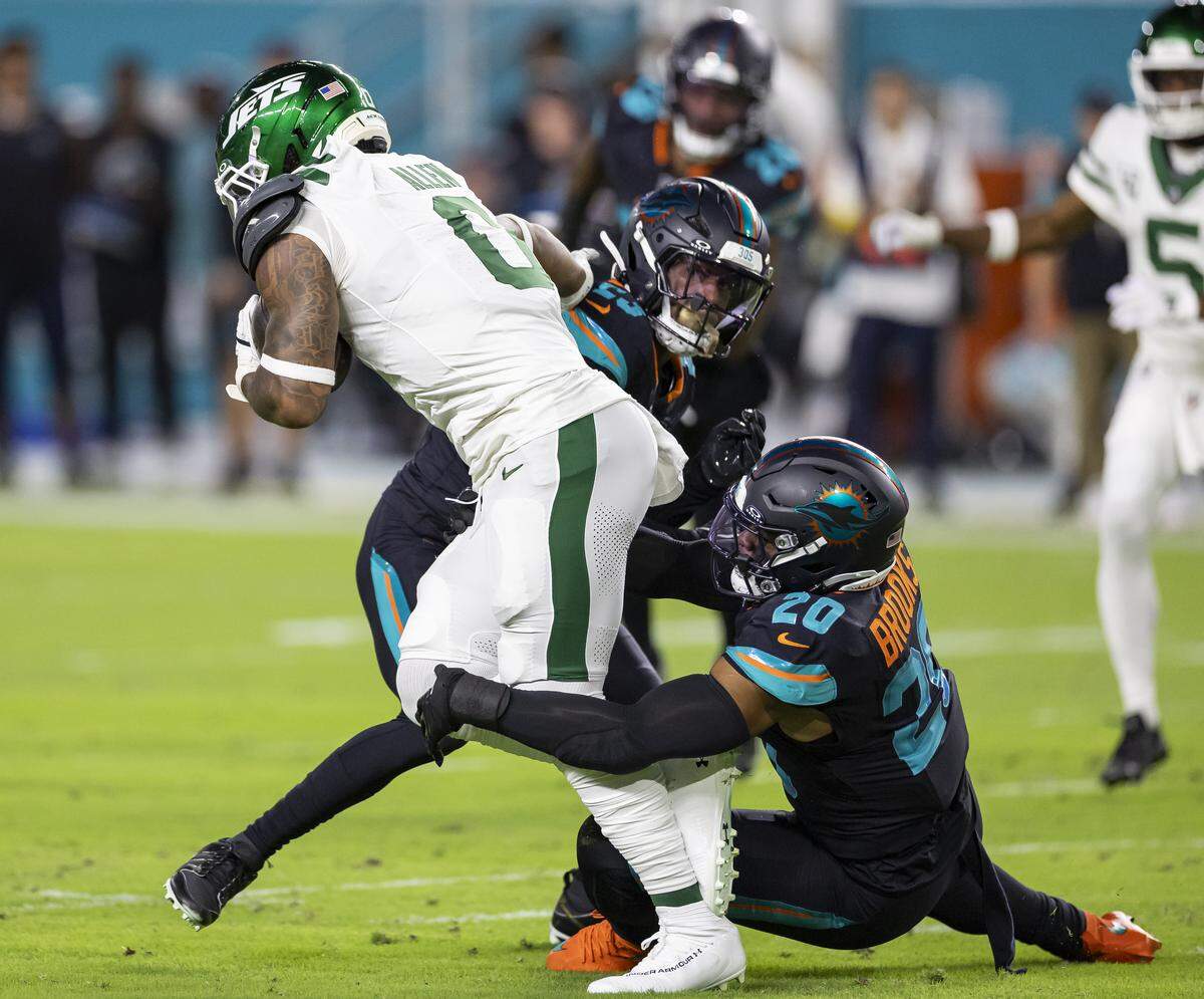 Miami Dolphins linebacker Jordyn Brooks (20) tackles New York Jets running back Braelon Allen (0) in the first half of their NFL game at Hard Rock Stadium on Monday, Sept. 29, 2025, in Miami Gardens, Fla.