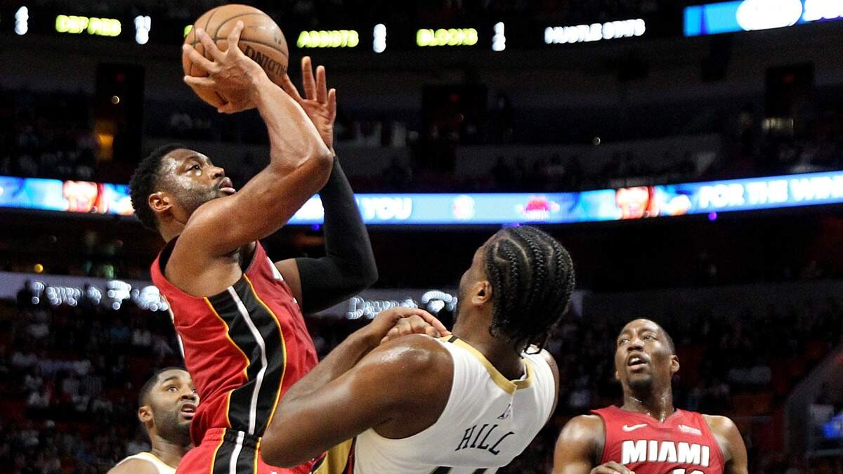 Dwyane Wade, del Heat (izq.), tira sobre el delantero de los Pelicans Solomon Hill, este viernes en el American Airlines Arena.