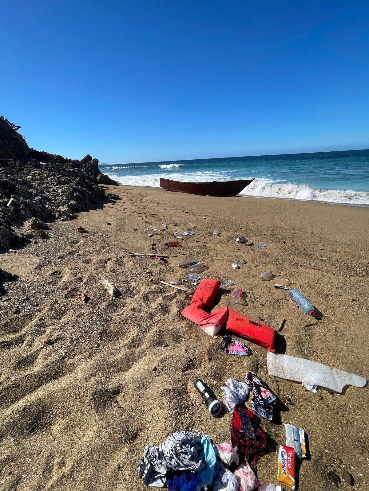 El bote en la playa de Rincón, Puerto Rico, el 24 de enero de 2022, junto con artículos que supuestamente dejaron los inmigrantes haitianos.