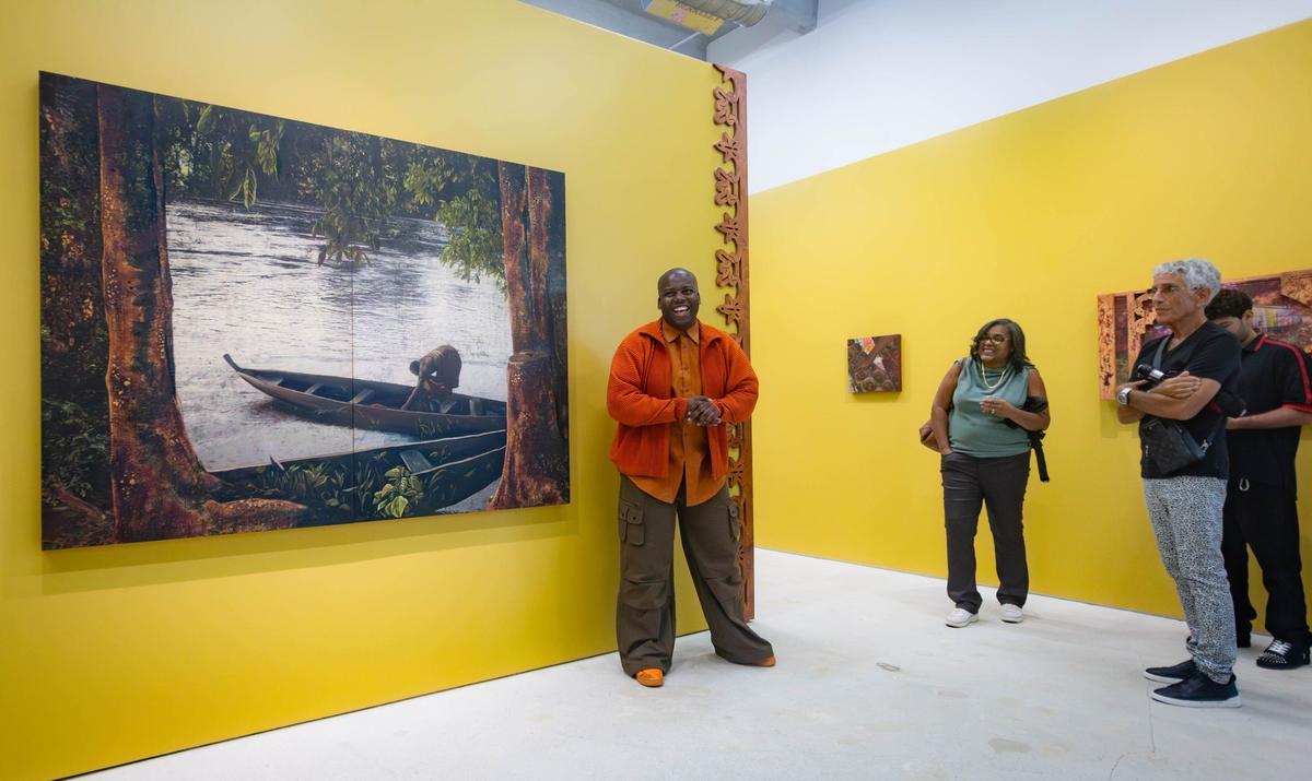 Cornelius Tulloch (center) explains his work to a crowd of guests before his solo show opening party at the Andrew Reed Gallery on Thursday, July 11, 2024 in Miami, Fla.