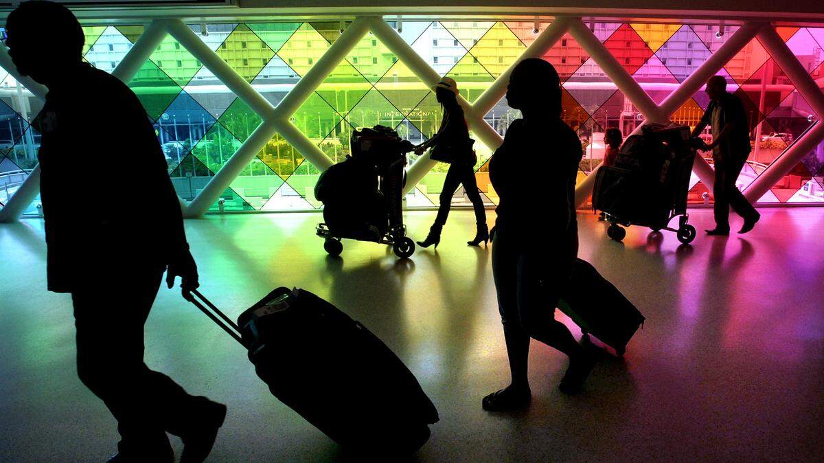 Travelers make their through a third-level walkway at Miami International Airport, at the junction of the Dolphin and Flamingo parking garages and the new MIA Mover stop. A software glitch that prevented some travelers from paying their tickets at the airport’s parking garages has reportedly been fixed.