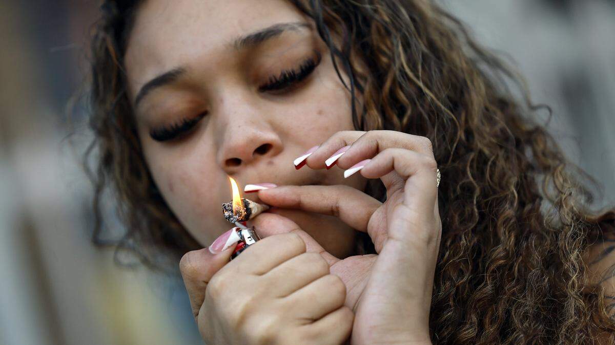 Crista lights up a marijuana cigarette during Spring Break along Ocean Drive, Miami Beach, Florida on Friday, March 14, 2025. 