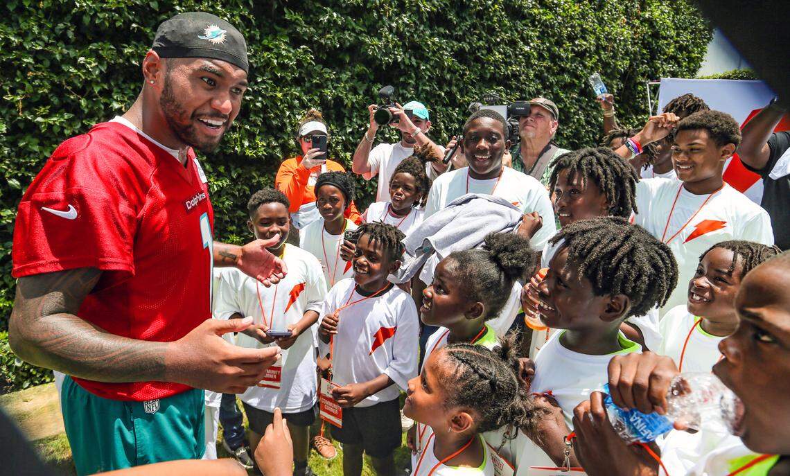 Miami Dolphins quarterback Tua Tagovailoa was greeted by children after practice as the Dolphins gave backpacks, supplies to students ahead of the 2024 school year at the Miami Dolphins training facility in Miami Gardens, FL, on Aug. 1, 2024.