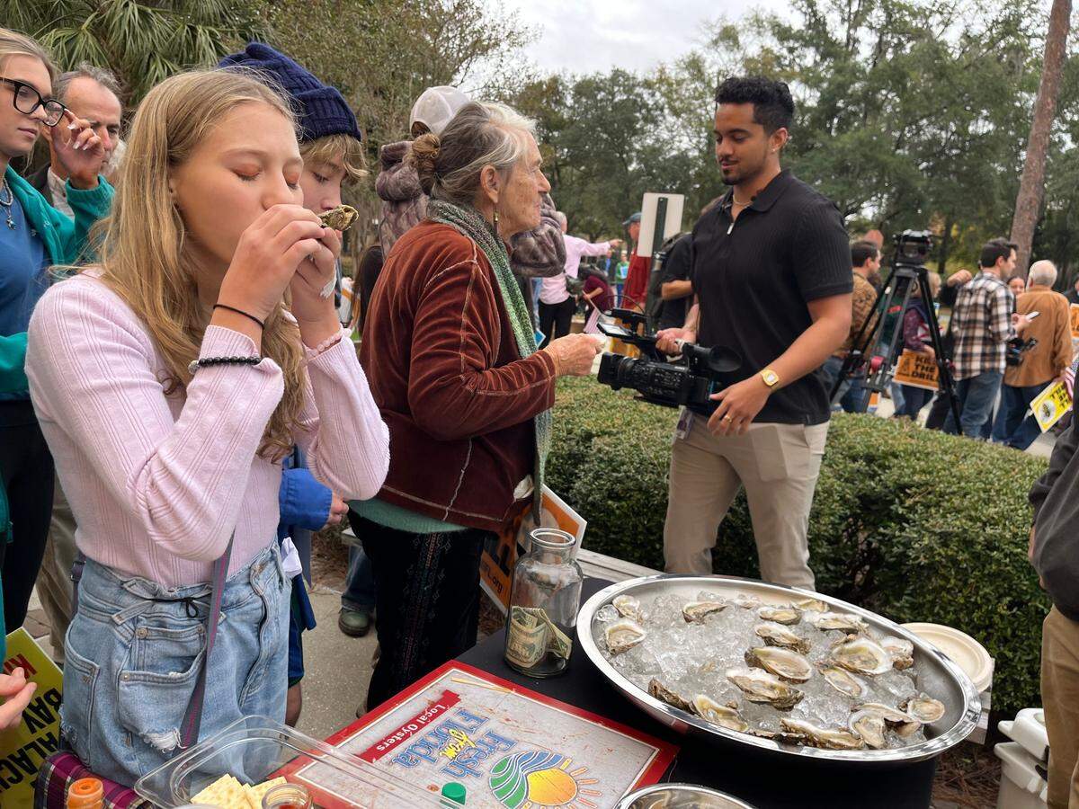 Nina Ozerova, 13, eats an oyster from Apalachicola Bay the Florida Department of Environmental Protection’s headquarters in Tallahassee on Monday, Dec. 9, 2024. Ozerova was one of several students who spoke in protest of a plan by a Louisiana company to drill an exploratory oil and gas well in the bay.