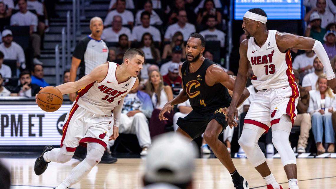 Miami Heat guard Tyler Herro (14) dribbles as center Bam Adebayo (13) attempts to set a pick on Cleveland Cavaliers forward Evan Mobley (4) during the second half of Game 3 of the NBA Playoffs at Kaseya Center on Saturday, April 26, 2025, in Miami, Fla.