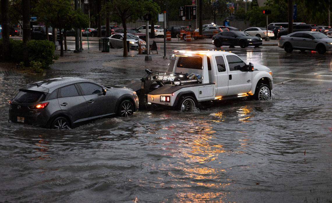 A car stalls out on NE 11th St and gets towed out of flooded water during a flash flood warning on Monday, June 2, 2025 in downtown Miami, Fla.