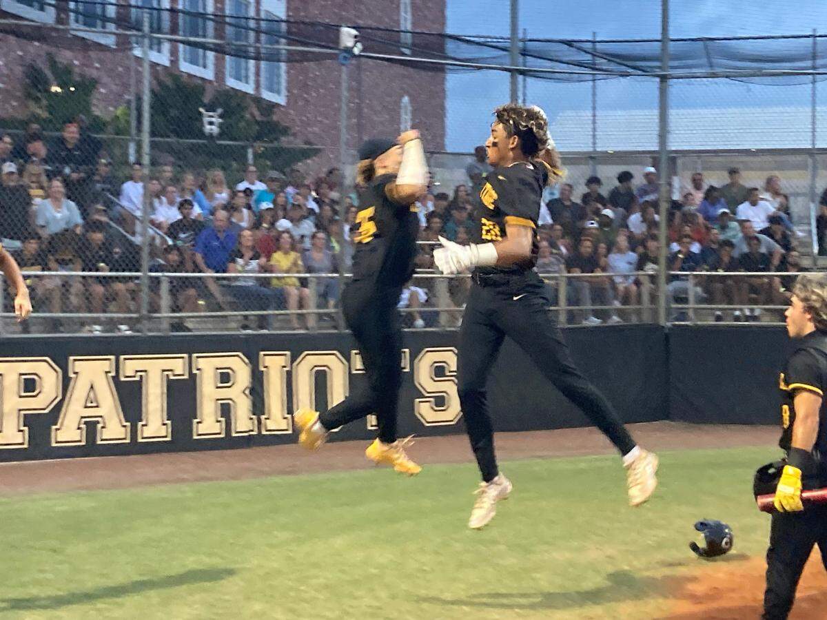 American Heritage’s Luca Ramirez (right) is greeted at the plate and celebrates with a teammate following his fourth-inning home run against Archbishop McCarthy on Monday in the Region 4-5A baseball final.