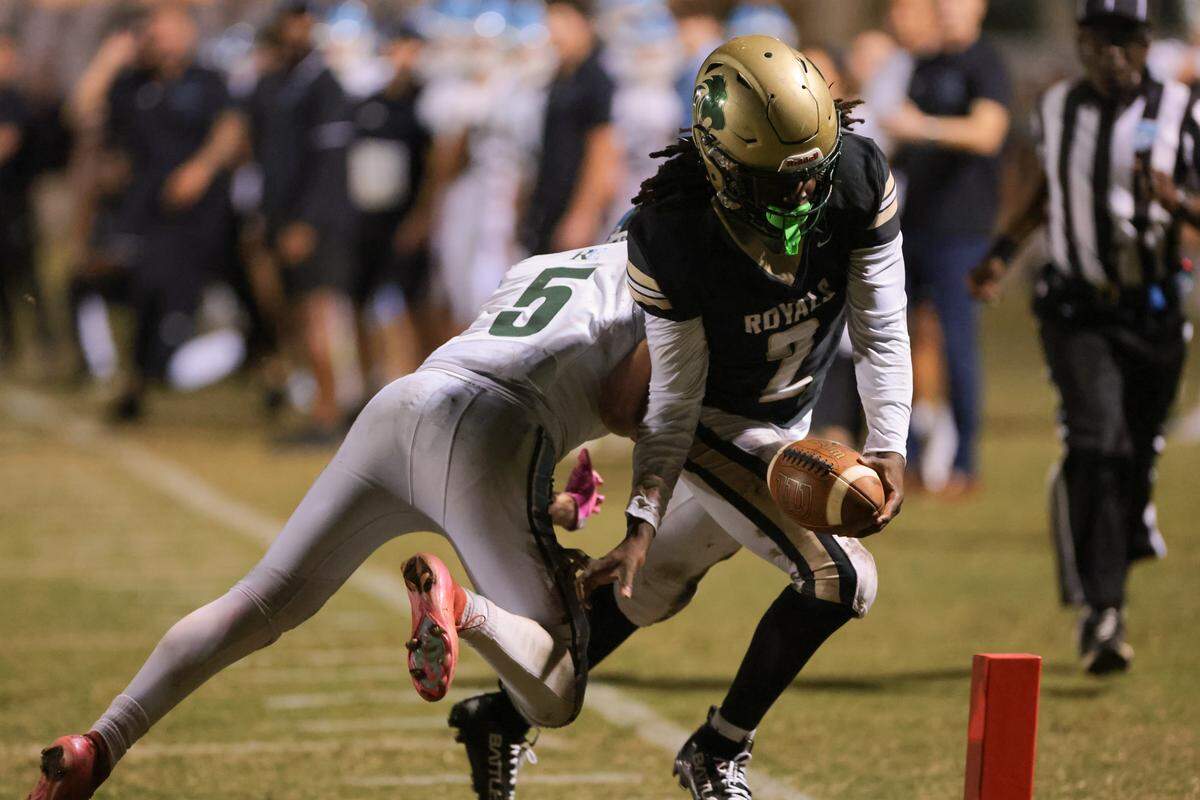 Immaculata-La Salle running back Adrian Cox (2) scores a touchdown against Ransom Everglades free safety Landon Elfenbein (5) during the first quarter of a Region 4-2A semifinal playoff game at Immaculata-La Salle High School on Friday, Nov. 21, in Miami, Fla.