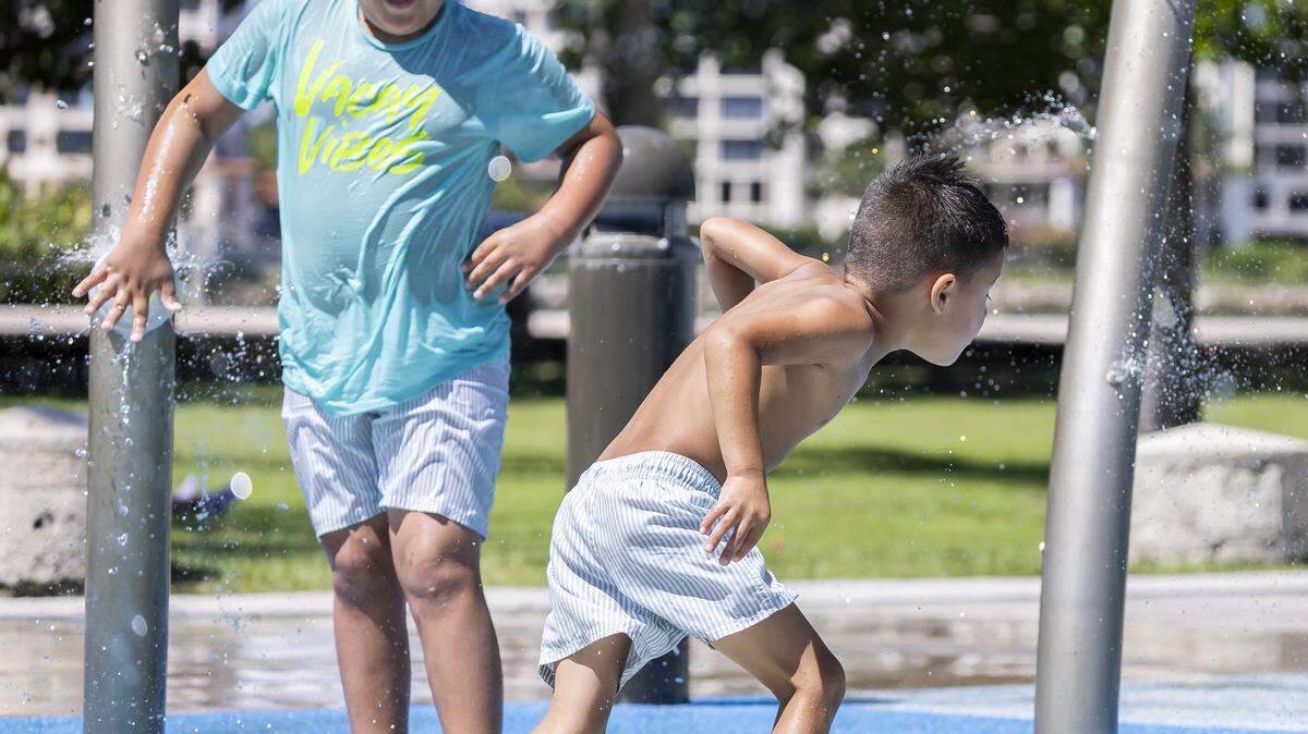 Mateo Tuesta, 7, activates a splash pad as his brother, Tiago Tuesta, 4, runs to avoid the water at South Pointe Park as hot weather moves through the area on Friday, Aug. 15, 2025, in Miami Beach, Fla. Forecasters have issued heat advisories throughout the summer in South Florida, with temperatures at times feeling as hot as 109 degrees.