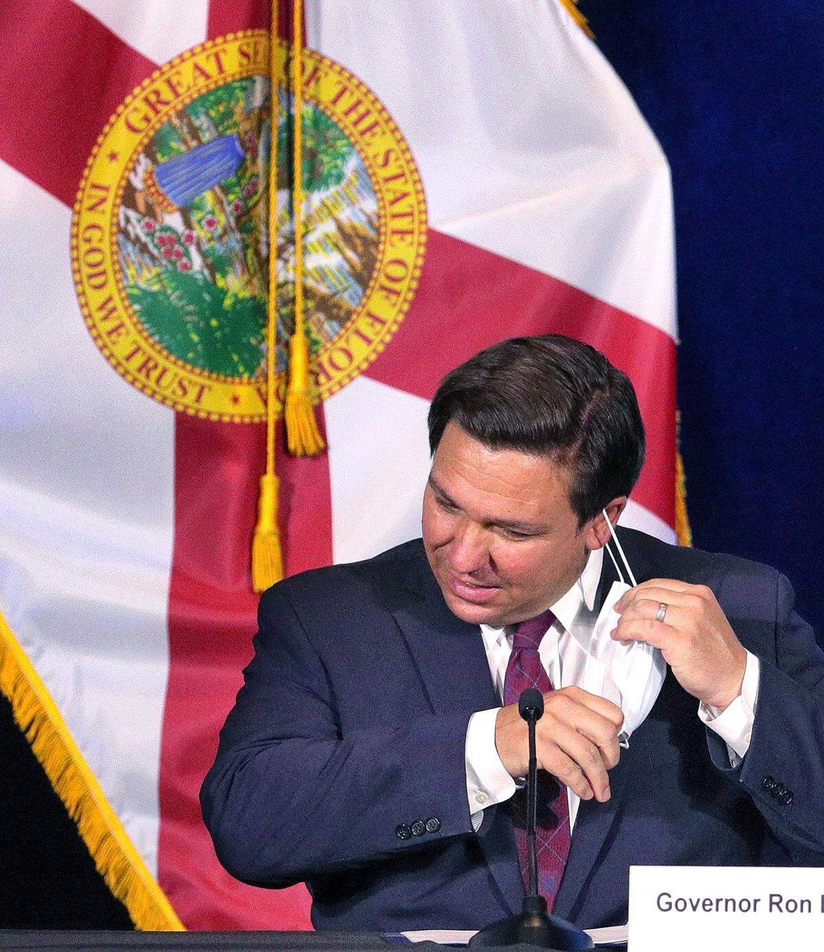 El gobernador Ron DeSantis se quita la mascarilla después de llegar a Universal Studios Florida en Orlando para participar en una mesa redonda con líderes de parques temáticos sobre protocolos de seguridad y el impacto de la pandemia del coronavirus, el miércoles 26 de agosto de 2020. Ejecutivos de Walt Disney World, Universal Orlando y SeaWorld Orlando pronunciaron discursos y respondieron a las preguntas del gobernador.