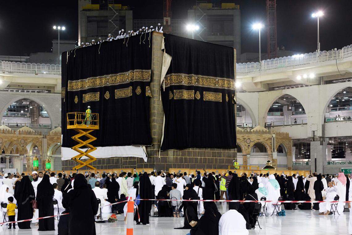 Saudi laborers change the Kiswa, the protective cover made from black silk and gold thread and embroidered with verses from the Quran, that engulfs the Kaaba in Saudi Arabia’s holy city of Mecca early on August 10, 2019. The Epstein Files show that the disgraced financier received the drapes as a gift. (RAEID ALLEHYANI/AFP via Getty Images)