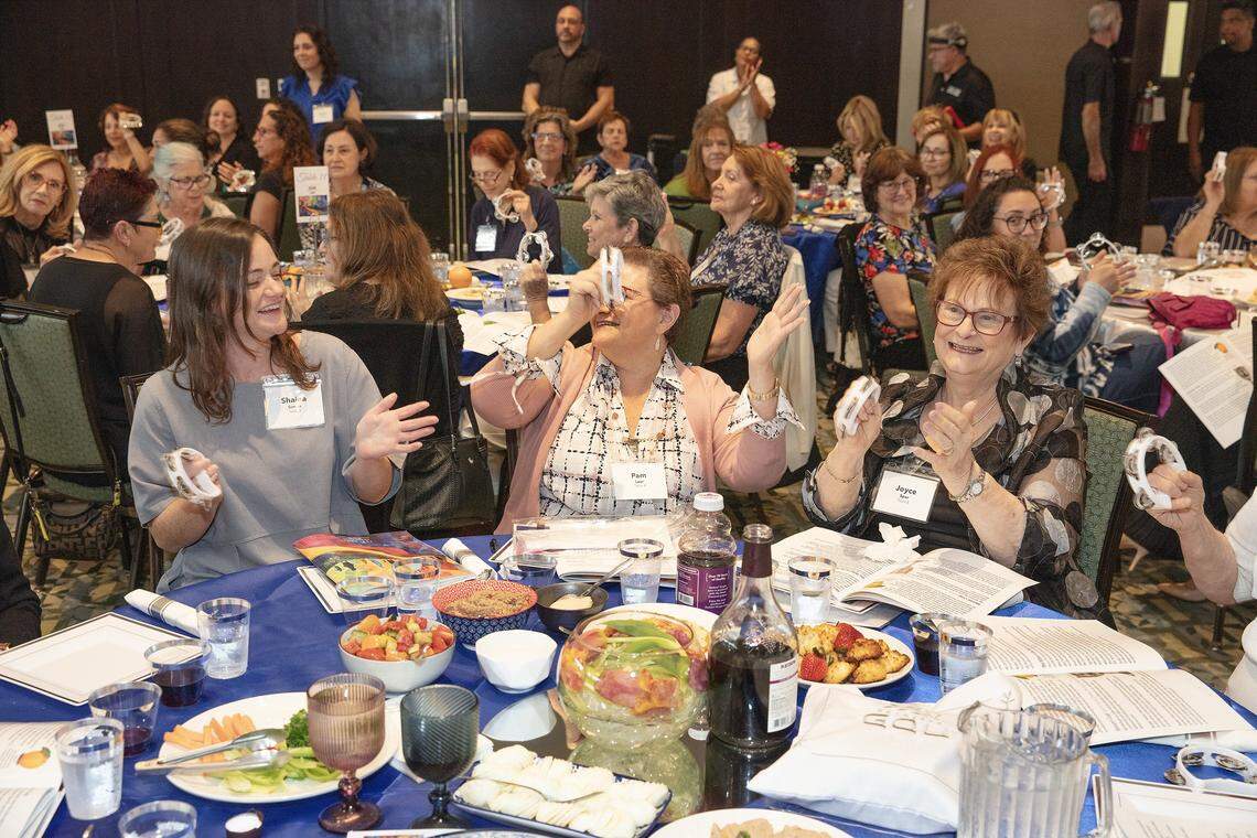 Participants in the Third Annual South Dade Community Women's Passover Seder (from the left) Shaina Simon, Pam Lear and Joyce Spar play tambourines on Sunday, March 30, 2026 at Temple Judea in Coral Gables. Andrew Uloza / for Miami Herald