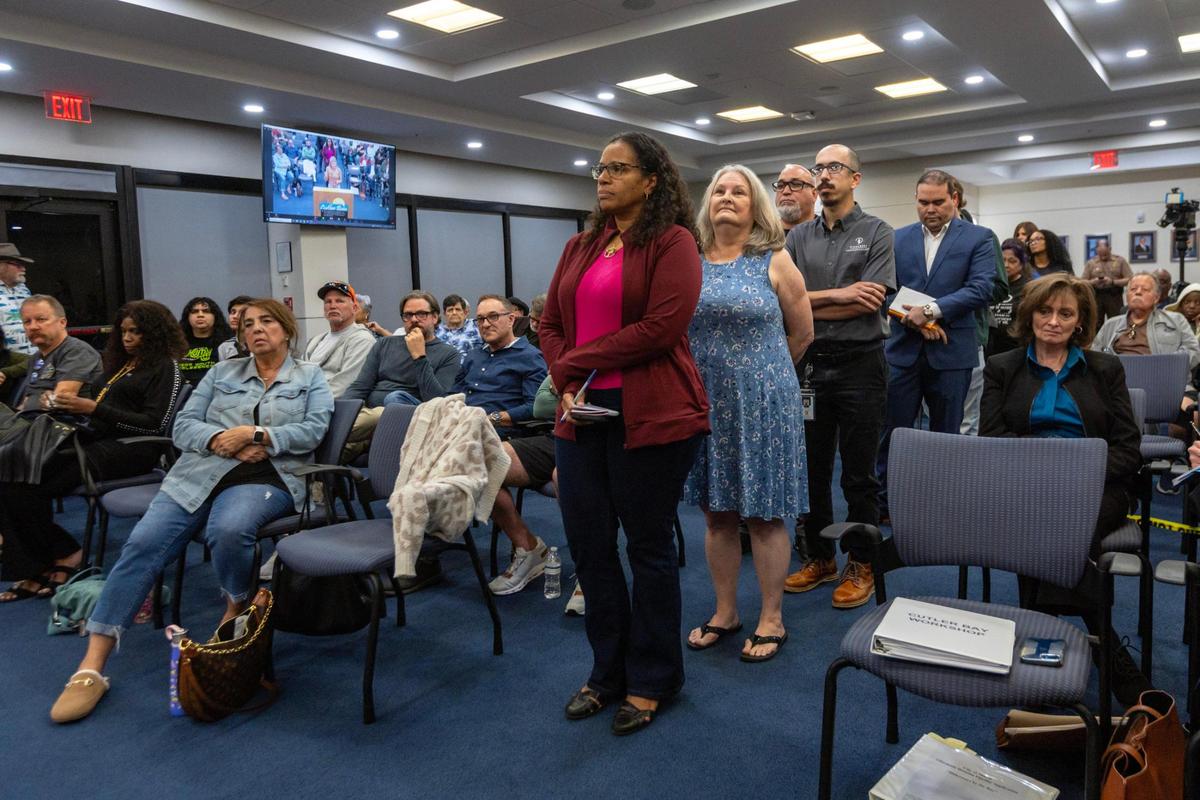 Personas hacen fila para hablar durante un foro del concejo municipal de Cutler Bay sobre un plan del Homeless Trust del Condado Miami-Dade para convertir un motel La Quinta Inn en apartamentos asequibles para personas sin hogar.