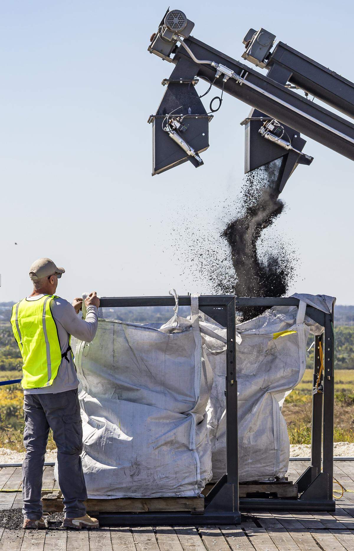 Jack Prather, vice president of business development with Clean Earth Innovations, ties up a bag of biochar during the opening of the company's new pilot program at the South Dade Landfill on Friday, Feb. 6, 2025, in Homestead, Fla.