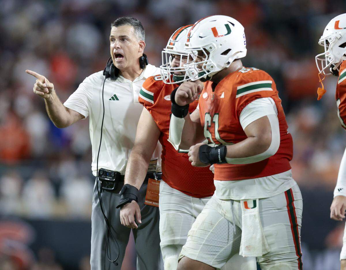 Miami Hurricanes head coach Mario Cristobal gestures as players run onto the field during their NCAA football game against the Florida Gators in the second half at Hard Rock Stadium in Miami Gardens, Florida, on Saturday, September 20, 2025.