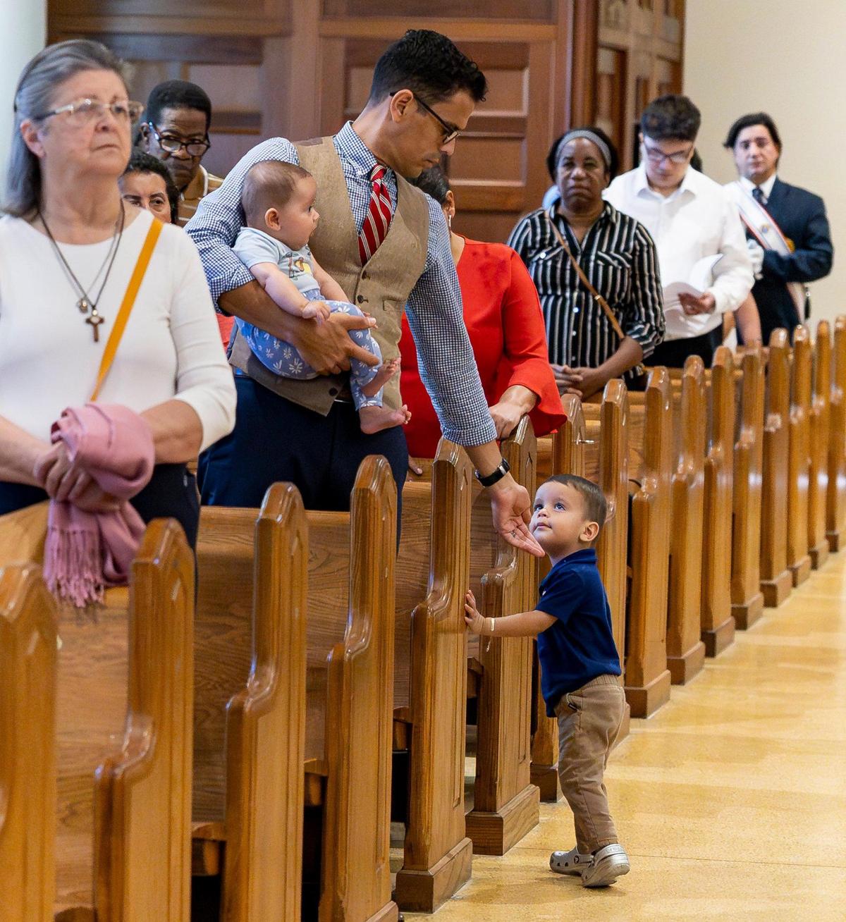 John Vargas, his 4-month-old daughter, Maria Caterina Vargas, and his son, Charbel Vargas, 1, attend a Good Friday service at the Cathedral of St. Mary on Friday, April 18, 2025, in Miami, Fla.
