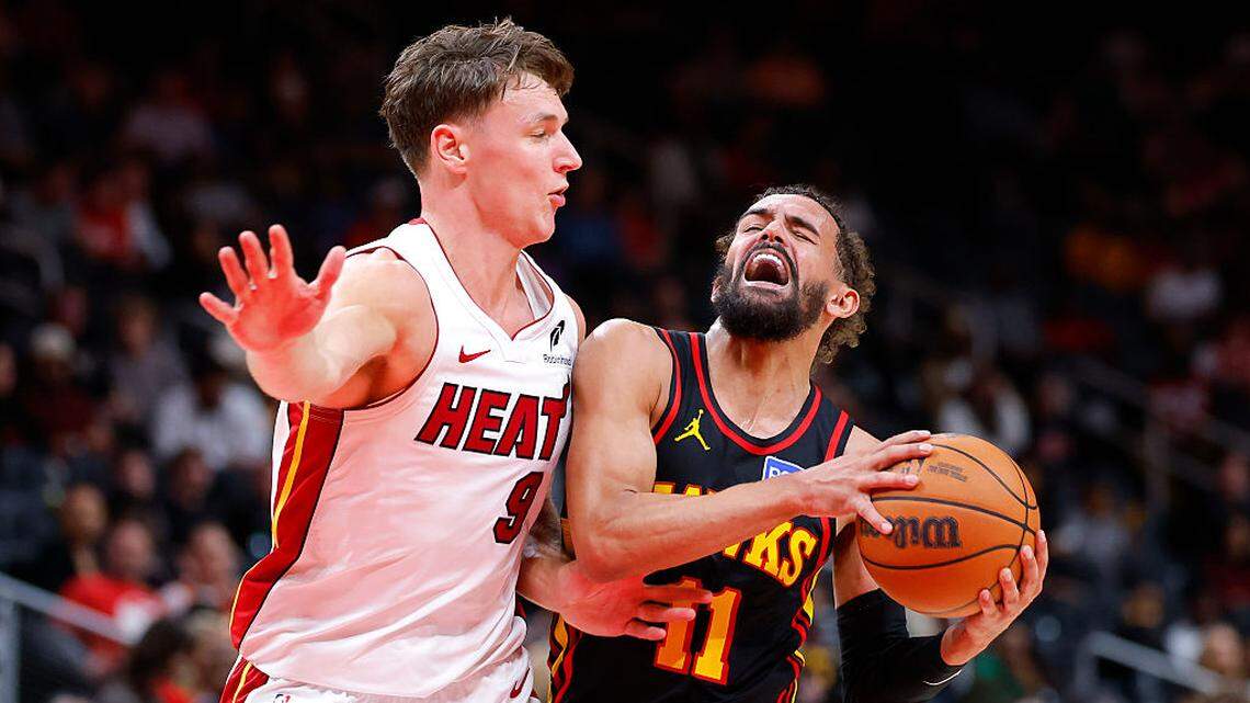 Trae Young #11 of the Atlanta Hawks battles Pelle Larsson #9 of the Miami Heat during the fourth quarter at State Farm Arena on December 26, 2025 in Atlanta.