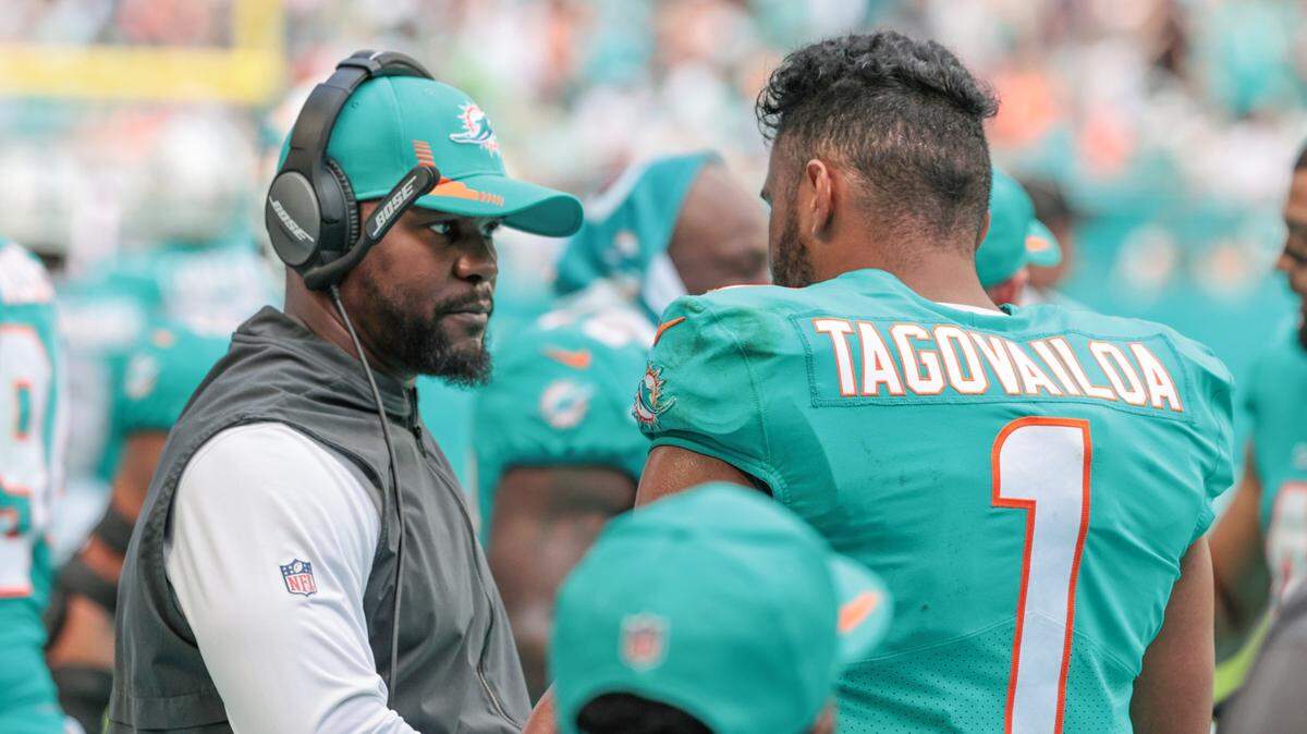 Miami Dolphins head coach Brian Flores talks with Miami Dolphins quarterback Tua Tagovailoa (1) during game against the New York Jets at Hard Rock Stadium in Miami Gardens on Sunday, December 19, 2021.