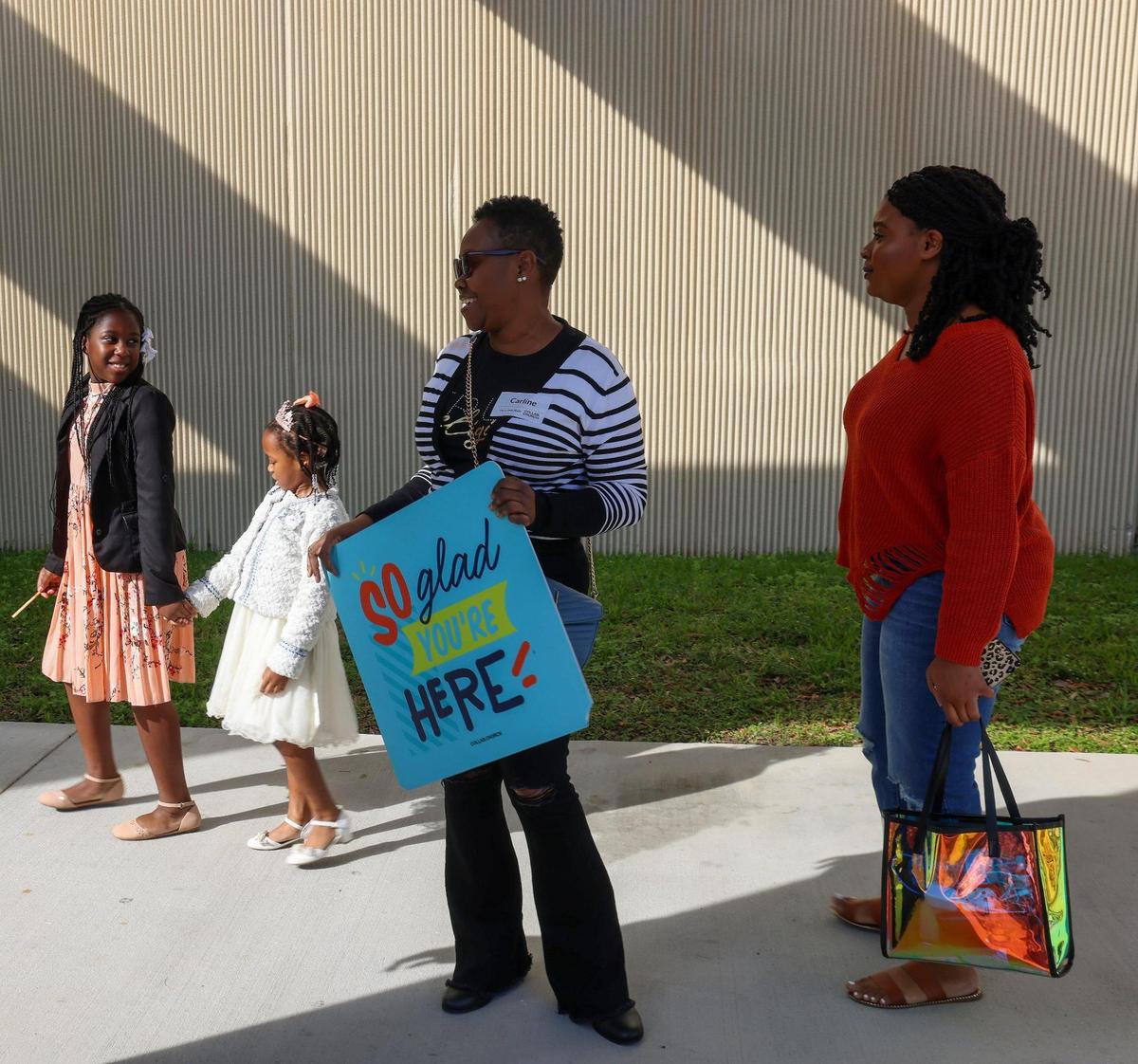 Greeter Carline Larson, center, welcomes worshipers to Sunday service on January 21, 2024, in Miami Gardens, Florida. The Assemblies of God church sold its eight-acre property to developers in 2022, and the church rebranded to Collab.Church the same year at operates temporarily inside the auditorium of the North Dade Middle School.