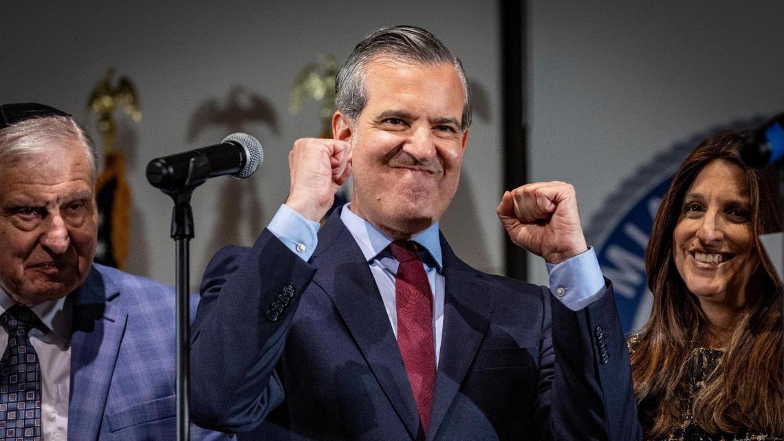 The new mayor of Miami Beach, Steven Meiner, gestures after being sworn in during a ceremony at the Miami Beach Convention Center. He is flanked by his wife Shanyn, right, and his father Sheldon Meiner, left, who joined him on stage for the ceremony, Tuesday, November 28, 2023.