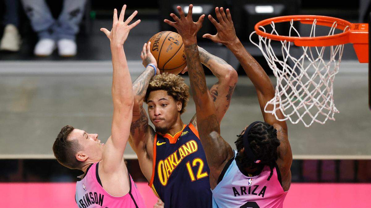 Golden State Warriors guard Kelly Oubre Jr. (12) looks to pass against Miami Heat players Duncan Robinson (55) and Trevor Ariza (8) in the first quarter of their NBA basketball game at the AmericanAirlines Arena on Thursday, April 1, 2021 in Miami, Fl.