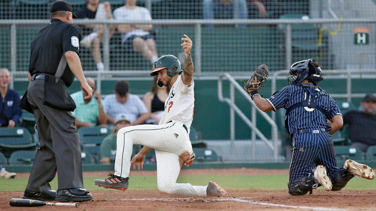 UM Hurricanes infielder CJ Kayfus slides home base against the FIU Panthers on Wednesday, April 6, 2022 at Alex Rodriguez Park at Mark Light Field in Coral Gables.