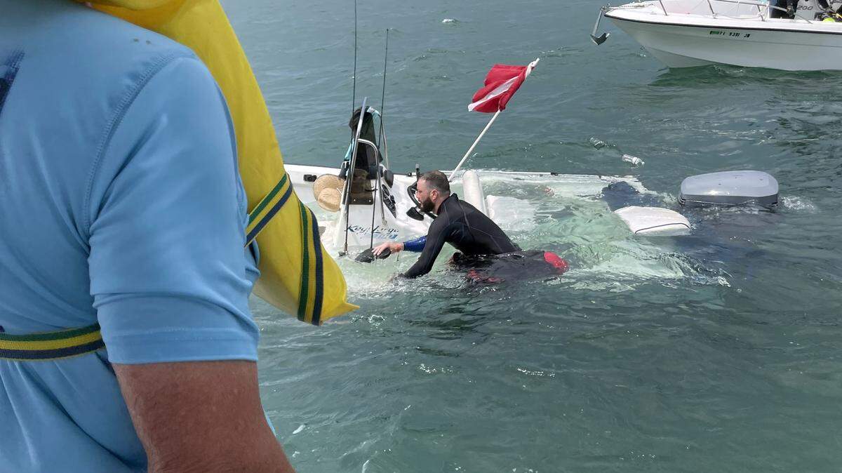 A man clings to a sinking boat near the Old Seven Mile Bridge in the Florida Keys Thursday, July 27, 2023.