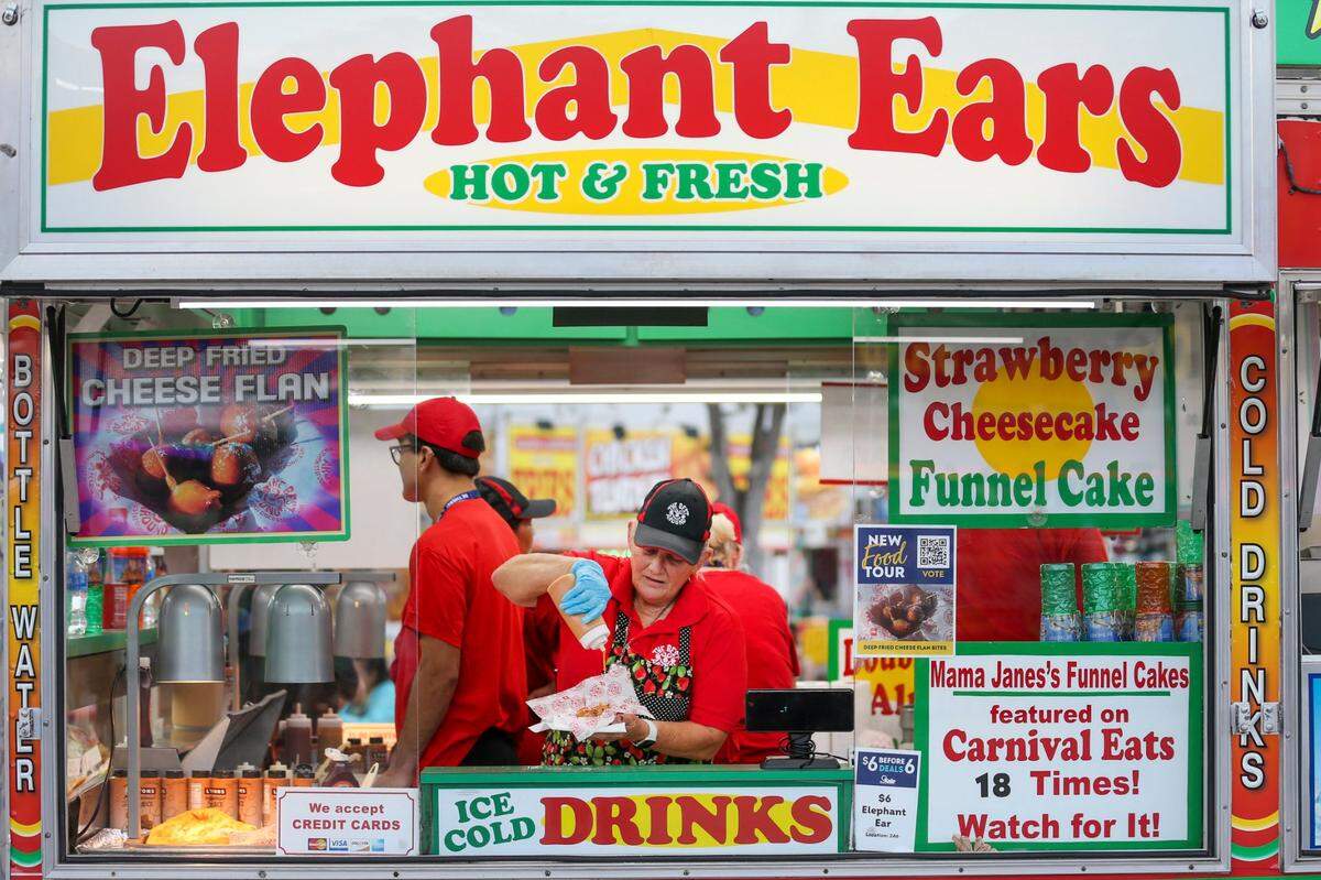 Mama Jane Harris adds Dulce de Leche topping to deep fried cheese flan bites during the opening day of the Miami-Dade County Youth Fair at the Miami-Dade Fair & Expo Center in Miami, Florida, on Thursday, March 17, 2022.