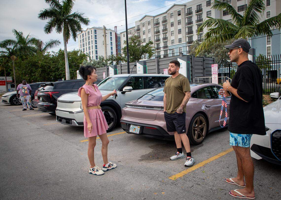 Tang P, Gerardo Yepes and Sebastian Yepes network while their cars charge in the Electrify charging station in the Walmart parking lot in Hialeah.