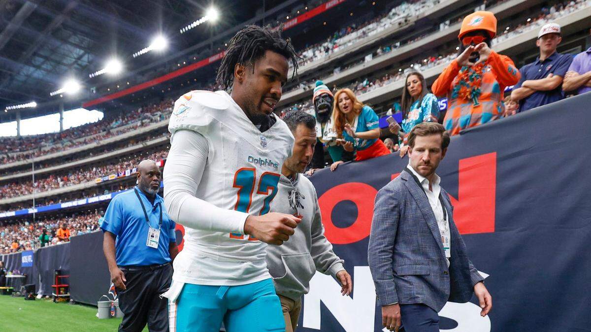 An injured Miami Dolphins wide receiver Jaylen Waddle (17) is escorted off the field during the first half of the NFL game against the Houston Texans at NRG Stadium in Houston, Texas, on Sunday, December 15, 2024.