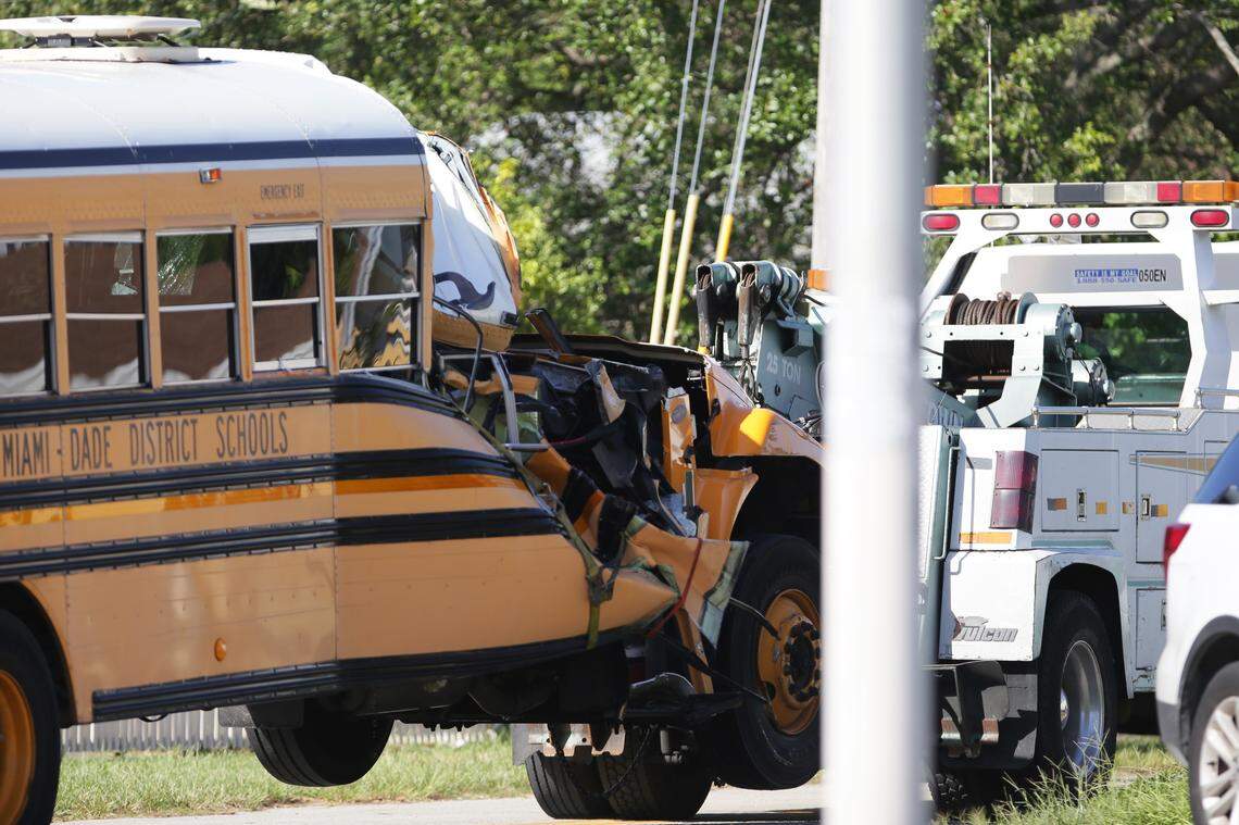 A tow truck removes the school bus involved in a collision with a garbage truck at Northwest 12th Avenue and 71st Street on Thursday, September 19, 2019, in Miami.