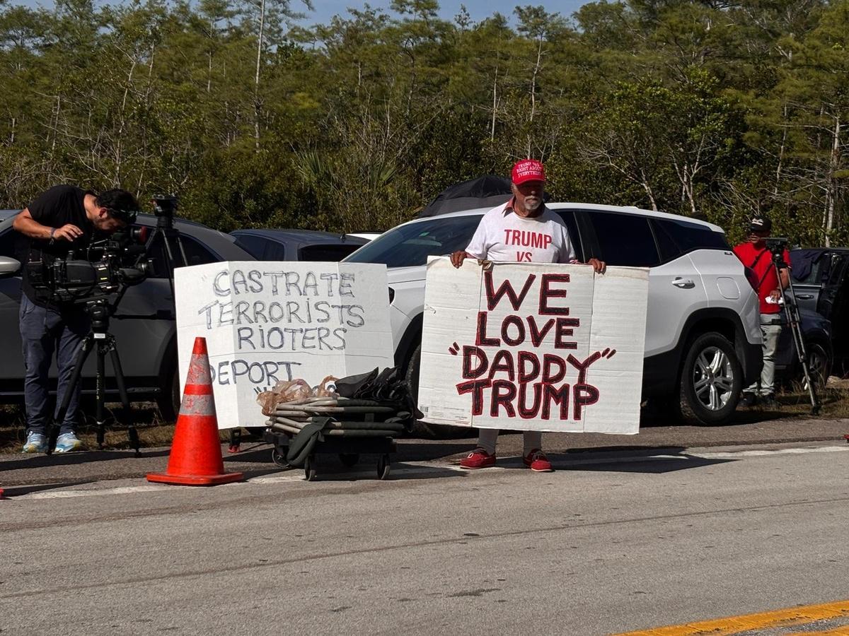 Ochopee, Florida, July 1, 2025 - Bob Kuntz, center, shows his support for President Trump as protesters rally near the Dade-Collier Training and Transition Airport in the Everglades, where the ‘Alligator Alcatraz’ detention center was built by the state. President Trump visited the center Tuesday.