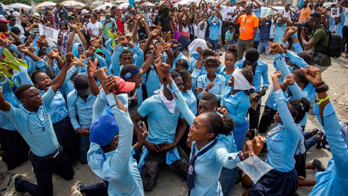 Students in their school uniforms kneel chanting anti-government slogans during a Nov. 5, 2020, protest march in Port-au-Prince, Haiti, to demand answers after the kidnapping and murder of high school senior Evelyne Sincère. The young woman was found in a trash heap on Nov. 1 after relatives said they were unable to pay the large ransom demanded by her captors.