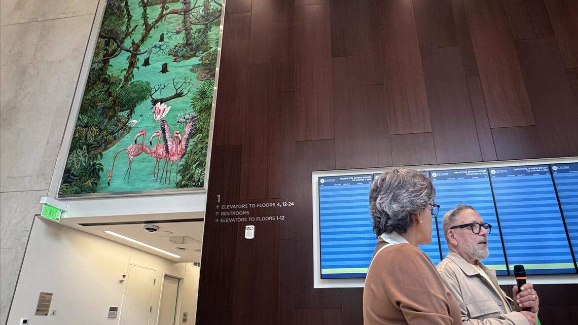 Haiti-born contemporary artist and curator Edouard Duval-Carrié, right, welcomes visitors to the Osvaldo N. Soto Miami-Dade Justice Center as they take a tour of the new courthouse, featuring Carrie’s two large murals in the lobby, on Saturday, December 6, 2025.