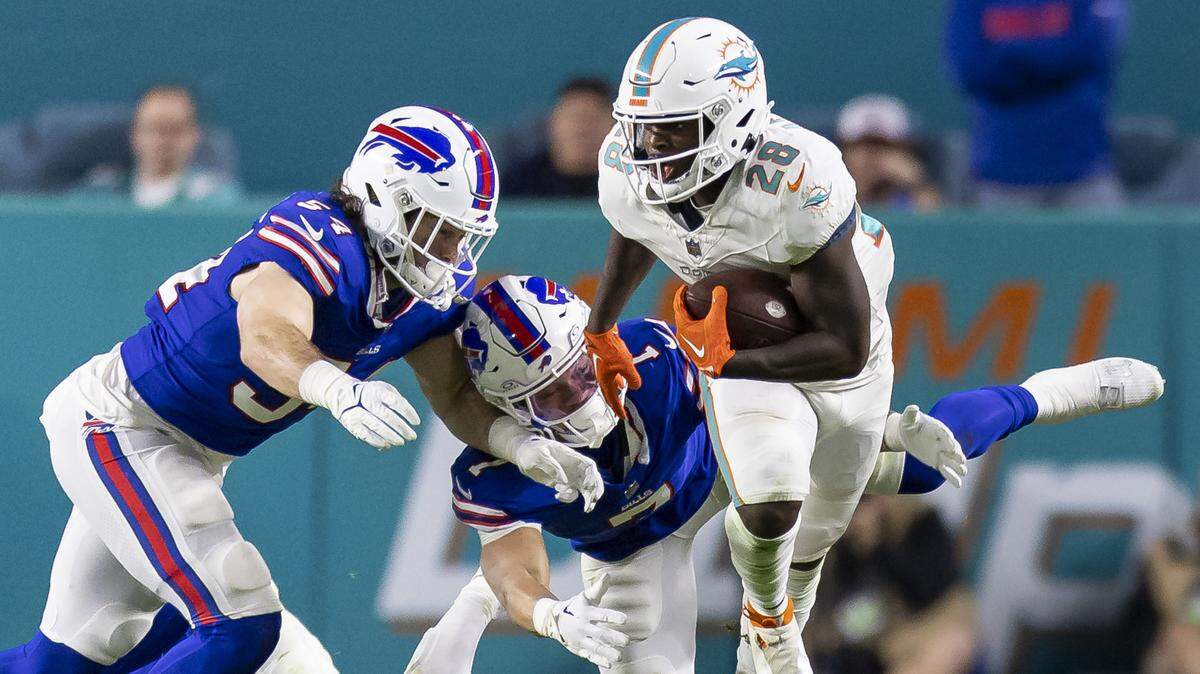 Miami Dolphins running back De’Von Achane (28) runs with the ball as Buffalo Bills linebacker Baylon Spector (54), cornerback Taron Johnson (7) and linebacker Terrel Bernard (43) try to tackle him in the second quarter of an NFL game at Hard Rock Stadium on Sunday, Jan. 7, 2023, in Miami Gardens Fla.