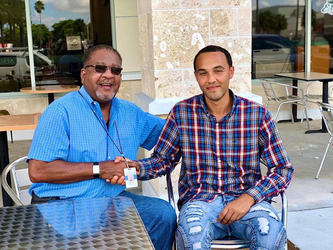 Steve Williams, left, shakes Michael Torres’ hand outside the Outrageous Bagel Co. in Kendall on Oct. 30. Williams is Torrres’ case manager at Here’s Help. 
