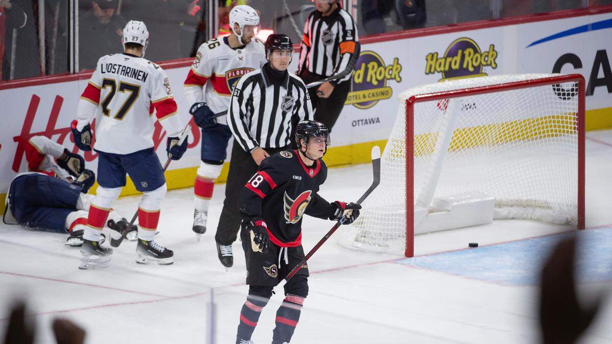 Oct 10, 2024; Ottawa, Ontario, CAN; Ottawa Senators center Tim Stutzle (18) scores an empty net goal after battling with Florida Panthers center Aleksander Barkov (16) who sustained an injury on the play in the third period at the Canadian Tire Centre. Mandatory Credit: Marc DesRosiers-Imagn Images