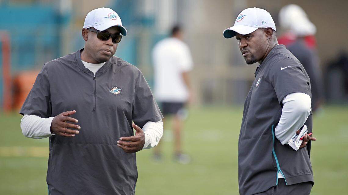 Miami Dolphins General Manager Chris Grier (left) and coach Brian Flores, seen here watching an offseason practice, have been speaking with draft prospects.