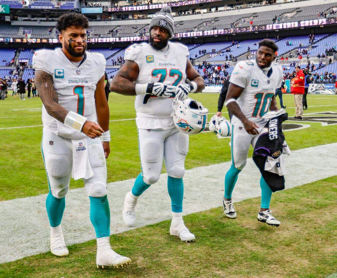 Miami Dolphins quarterback Tua Tagovailoa (1) walks off the field with teammates offensive tackle Terron Armstead (72) and wide receiver Tyreek Hill (10) after the loss against the Baltimore Ravens at M&T Bank Stadium in Baltimore, Maryland on Sunday, December 31, 2023.