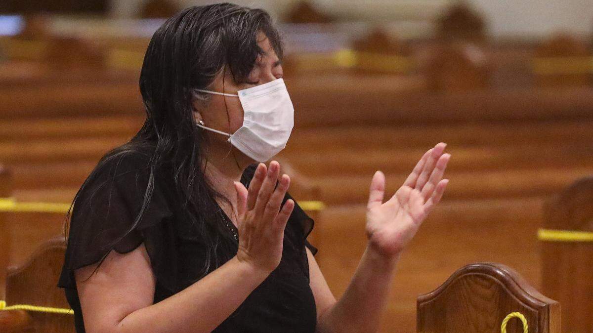 A worshiper prays while attending the 8:15 a.m. English Mass at the Cathedral of Saint Mary on Tuesday, May 26, the first day that Catholic churches in the Archdiocese of Miami reopened after in-person Masses were suspended in mid-March due to COVID-19.
