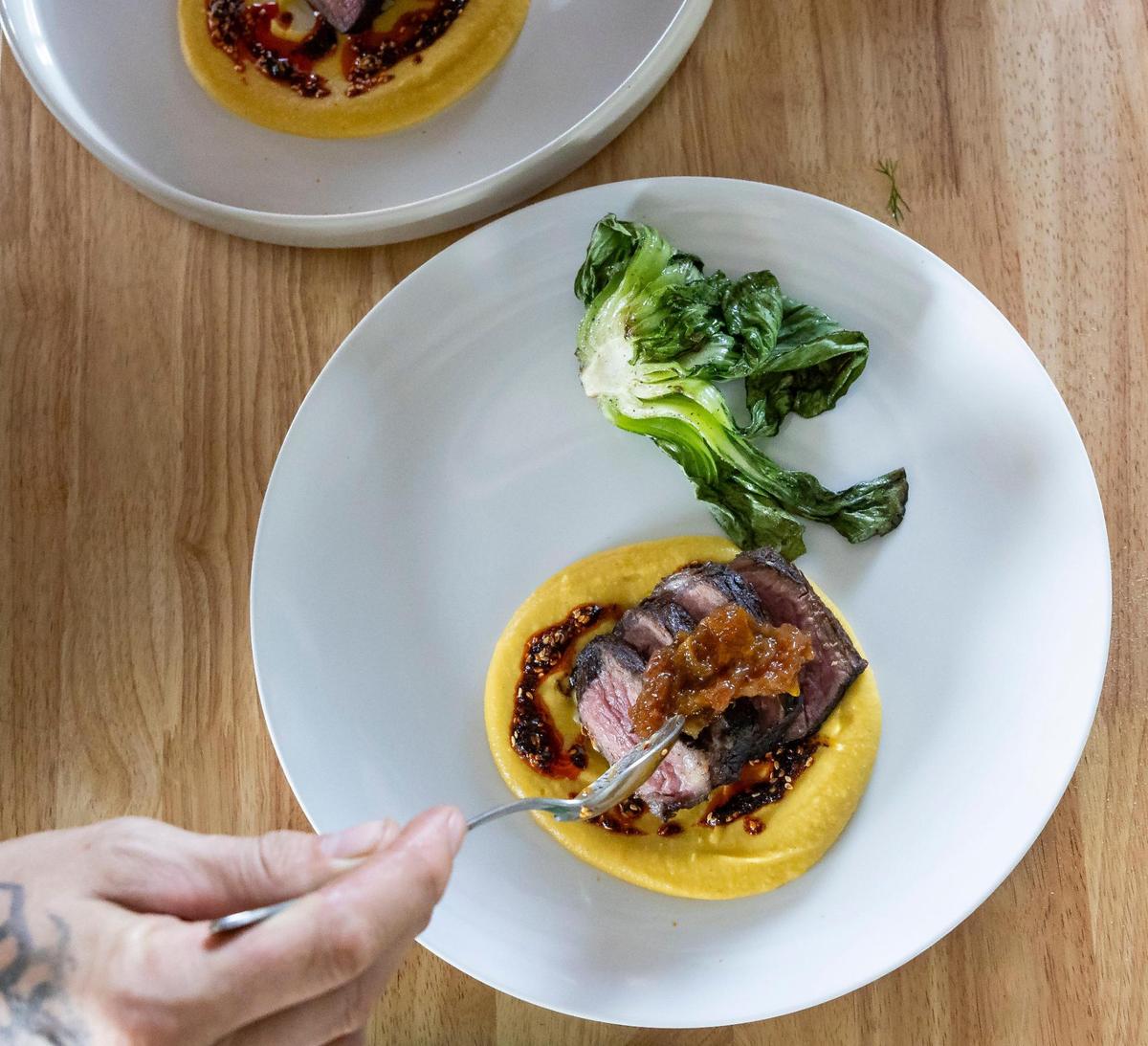 Chef Jeremy Ford, whose restaurant Stubborn Seed has received a Michelin star rating for the past three years, plates a lunch made from various ingredients from the fields of Ford’s Farm, including cabbage, squash puree and peach preserves atop grilled steak.