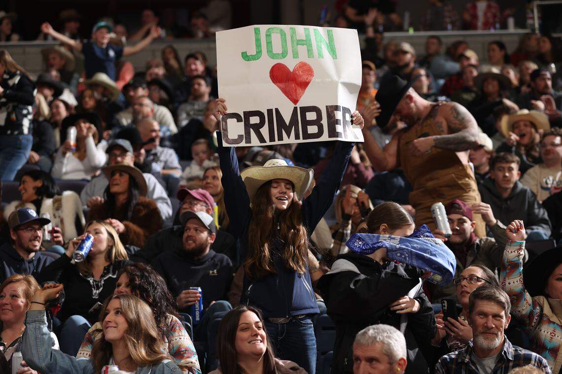 A young fan holds up a sign for John Crimber during the first round of the Professional Bull Riders event.