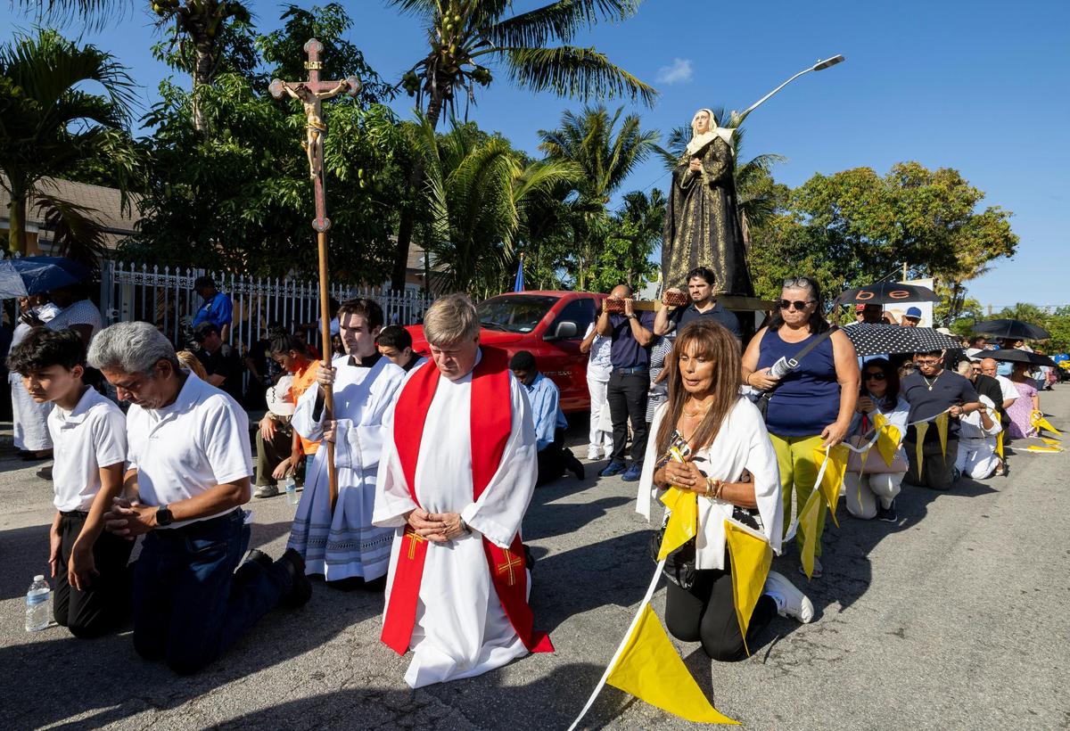 Fr. Stevn O’Hala, center, prays during a Living Stations of the Cross procession near the Cathedral of St. Mary on Friday, April 18, 2025, in Miami, Fla.