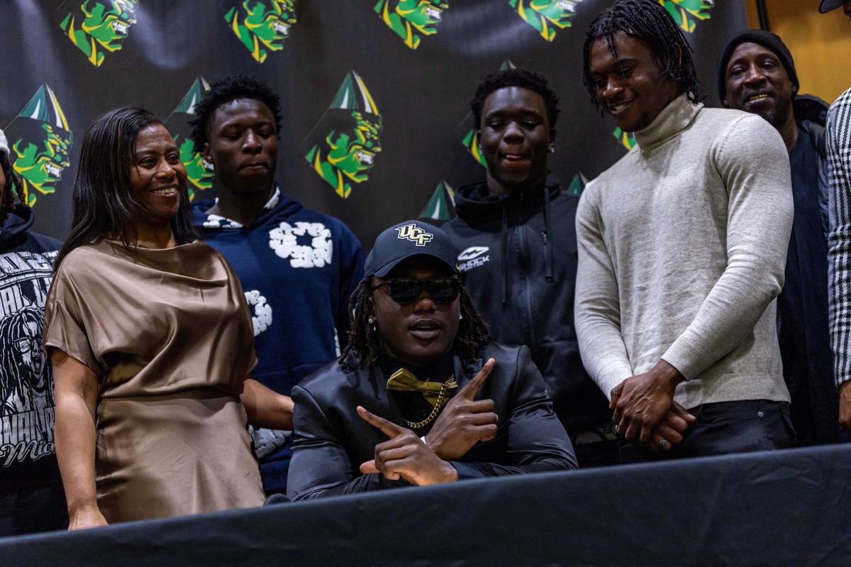 Miami Central’s Tony Williams reacts with family after he signed with University of Central Florida during signing day at Miami Central High School on Wednesday, Dec. 4, 2024, in Miami, Fla.