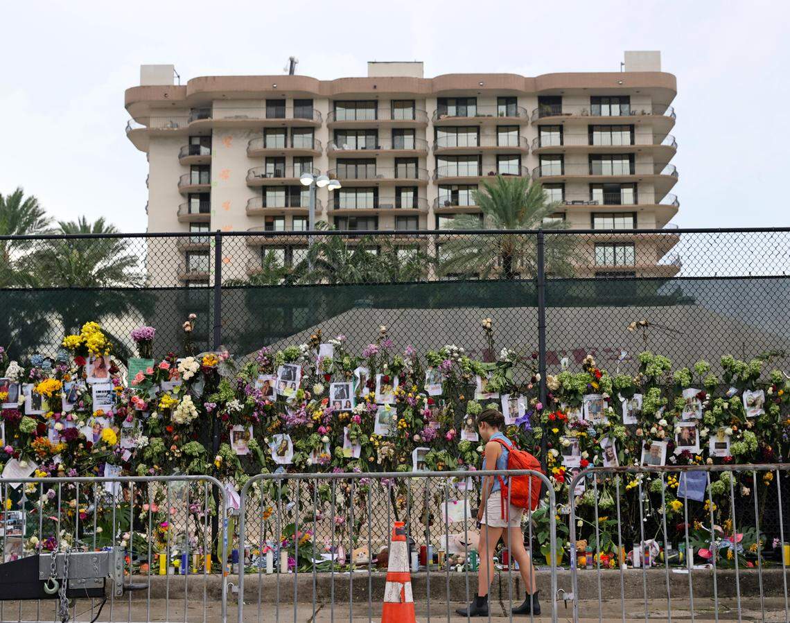 An unidentified woman visits the memorial wall full of photos of the missing and messages of love, support and prayers at Harding Avenue and 86th Street as the search and rescue personnel search continue for survivors through the rubble at the Champlain Towers South Condo in Surfside, Florida, Wednesday, June 30, 2021. The apartment building partially collapsed on Thursday, June 24.