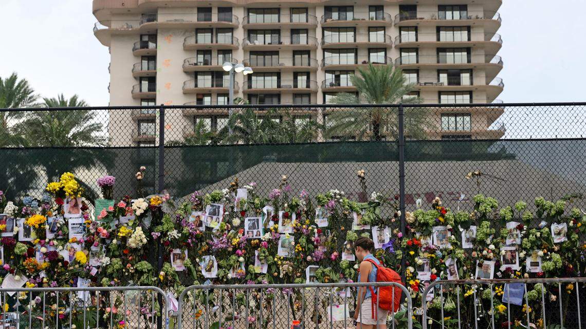 An unidentified woman visits the memorial wall full of photos of the missing and messages of love, support and prayers at Harding Avenue and 86th Street as the search and rescue personnel search continue for survivors through the rubble at the Champlain Towers South Condo in Surfside, Florida, Wednesday, June 30, 2021. The apartment building partially collapsed on Thursday, June 24.