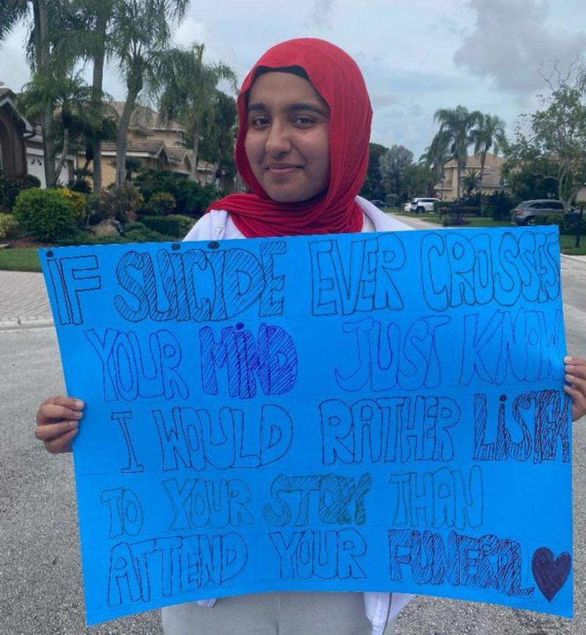 Leila Enver holds a sign encouraging people to talk about thoughts of suicide. The photo is a part of a new mental health campaign by the South Florida Muslim Federation.